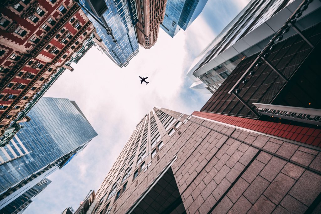 plane-in-the-sky-view-from-between-the-buildings